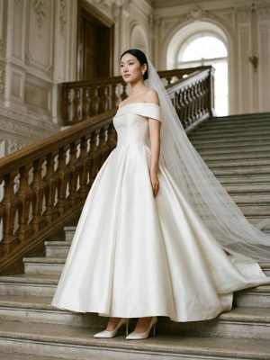 Vestido de novia de satén con escote bardot para una boda imperial